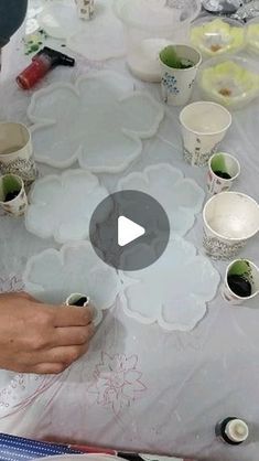 a table with plates and cups on it is being held by someone's hand