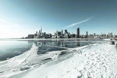 the city is covered in snow and ice as it sits next to the water's edge