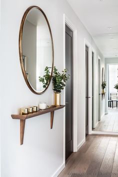 an iphone photo of a hallway with white walls and wood flooring on the phone