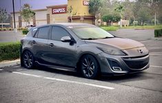 a gray car is parked in a parking lot