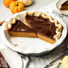 there is a chocolate pie on the table with pumpkins in the backgroud