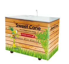 a wooden box that is sitting in the grass and has an advertisement on it for sweet cane