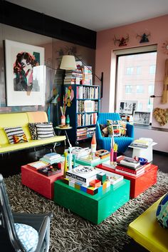 a living room filled with colorful furniture and bookshelves on top of each other