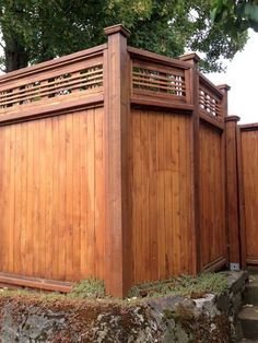 a large wooden fence next to a stone wall