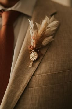 a man in a suit and tie with a feather brooch on his lapel