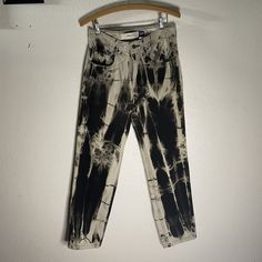 black and white tie - dye pants hanging on a hanger