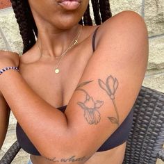 a close up of a person with a tattoo on her arm and arms behind her head