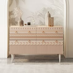 a white and beige dresser sitting in front of a wall with palm trees on it