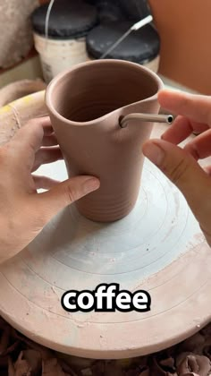 someone is making a cup out of clay and then using a spoon to stir it