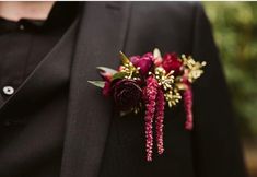 a man in a tuxedo with two flowers on his lapel flower pin