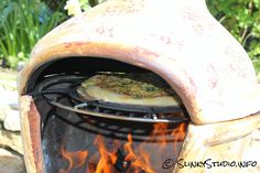 a pizza is cooking in an outdoor oven