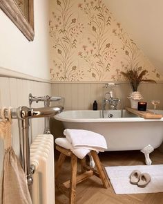 a white bath tub sitting next to a wooden stool