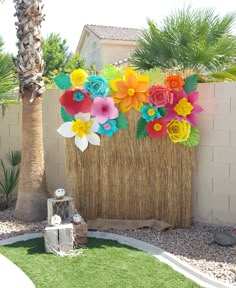 colorful paper flowers are on display in the back yard with artificial grass and palm trees