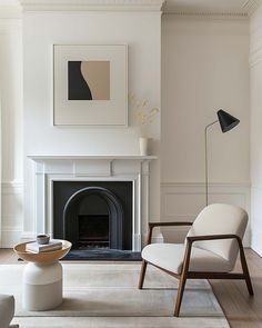 a living room with white furniture and a fire place in the corner, along with a painting on the wall