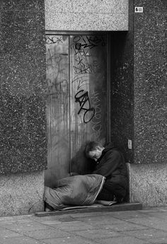 a man laying on the ground in front of a door with graffiti all over it