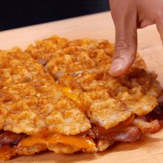 a person reaching for some food on a wooden table