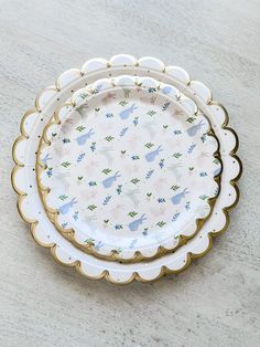 three plates sitting on top of a table next to each other with birds and flowers on them