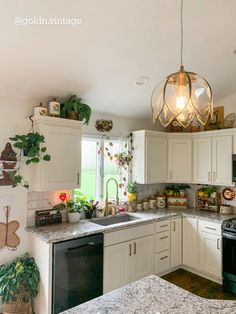 a kitchen with white cabinets and marble counter tops