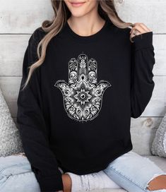 Hope you liked our Hamsa Hand Evil Eye Talisman Protection Long Sleeve T-Shirt, All Seeing Eye Mystical Hamsa Third Eye Shirt. Welcome to my store! Our shirts are designed to add joy and color to your life. Feel free to ask me anything you may need help with, I'm happy to assist you in any way. Happy Art by Lora - Brightens up your day Long sleeve shirt made with 100% ring-spun cotton Come packed with softness and style. Each tee features garment-dyed fabric comes with a relaxed fit for total comfort in any casual setting. .: 100% ring-spun cotton .: Medium fabric (6.1 oz/yd² (206.8 g/m .: Classic Fit .: Sewn-in twill label Bohemian Long Sleeve T-shirt With Relaxed Fit, Long Sleeve Bohemian T-shirt In Relaxed Fit, Black Bohemian Crew Neck Top, Witchy Hands, Eye Shirt, Hand Evil Eye, Seeing Eye, All Seeing Eye, All Seeing