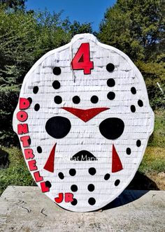 a cardboard mask with the number four on it is sitting in front of some trees