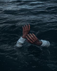 a man is floating in the water with his hands out