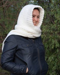 a woman wearing a hood and jacket in the woods