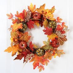 a wreath with autumn leaves and berries on it