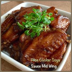 a white bowl filled with cooked meat and garnished with parsley on top