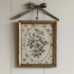 a painting hanging on the wall with a bow around it