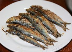 some fish are sitting on a white plate