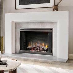 a modern fireplace in a living room with an art piece on the wall behind it