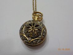 "Vintage 1928 brand pocket watch style locket pendant. 28\" chain with barrel fastener. Gold tone pocket watch style locket, including bale is 1 1/4\" x 3/4\". Hinged locket holds two photos. Gorgeous filigree design on the front of the locket & gold tone trim around the outer edge on the backside. This is in excellent vintage condition. Pre-owned & gorgeous! Signed with 1928 hang tag." Vintage Bronze Pocket Watch With Locket, Antique Bronze Pocket Watch With Locket, Antique Gold Pocket Watch With Locket For Formal Occasions, Vintage Hallmarked Round Pocket Watch, Antique Gold Locket Pocket Watch For Formal Occasions, Antique Round Pocket Watch With Antique Finish, Formal Antique Gold Pocket Watch With Locket, Antique Self-winding Pocket Watch As Gift, Antique Pocket Watch With Locket