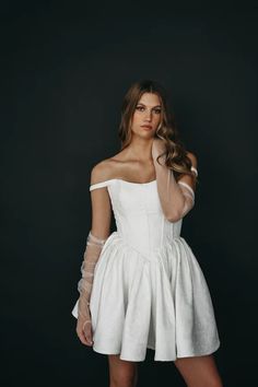 a woman in a white dress posing for the camera