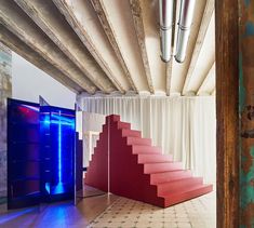 an empty room with red stairs and blue lights