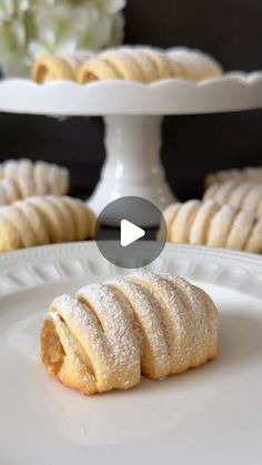 a white plate topped with cookies covered in powdered sugar on top of a table