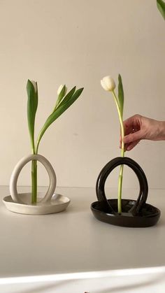 place white tulips into abstract ceramic vases with a loop that hold two stems upright with a plate that holds water Sculpture Art Ceramic, Vase From Clay, Pottery Hand Made, Ceramic Pieces Ideas, Clay Designs Ideas Art, Cute Clay Sculpture Ideas, Hand Sculpture Clay, Useful Ceramic Projects, Ceramic Ideas Aesthetic