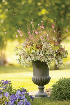 a planter filled with lots of flowers sitting on top of a lush green field