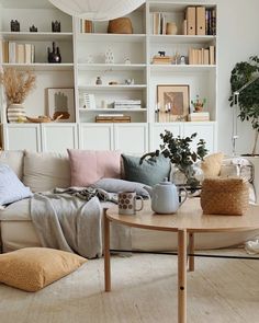 a living room filled with lots of furniture and bookshelves on top of shelves