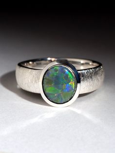 Silver ring with natural dark Opal Opal gemstone origin - Australia opal measurements  - 8 x 9.40 mm weight of Opal 1.71 ct ring weight - 4.9 grams ring size - 8 1/2 US, diameter 18.5 mm, N 18, 58 circumference Worldwide shipping from Berlin, Germany. Prices include all taxes, valid in Germany and in European Union countries on the Customer's order date. Price does not include import taxes and custom duties. It is the Customer's full liability to pay any possible customs duties, import taxes or Untreated Round Opal Ring As A Gift, Untreated Round Opal Ring As Gift, Untreated Round Opal Ring For Gift, Modern Round Opal Ring, Modern Opal Ring For Anniversary, Modern Oval Cabochon Opal Ring As Gift, Green Opal Ring In Sterling Silver For Gift, Silver Opal Cabochon Ring As Gift, Handmade Green Opal Ring In Sterling Silver