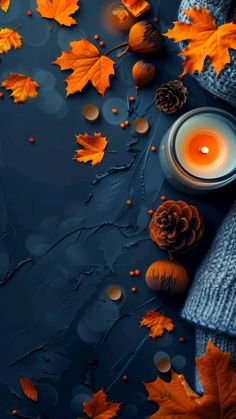 autumn leaves and candles on a dark blue background with falling acorns around it