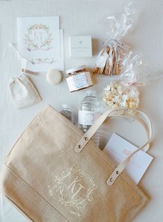 the contents of a handbag are laid out on top of a white tablecloth