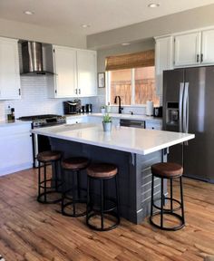 a kitchen with an island and stools in it