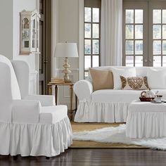 a living room filled with white furniture and lots of pillows on top of it's covers