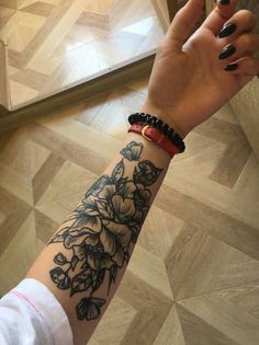 a woman's arm with a flower tattoo on it