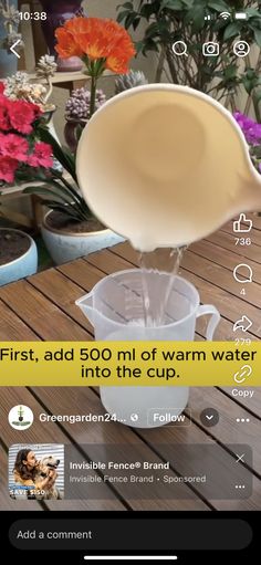 an image of water being poured into a cup on a table with flowers in the background