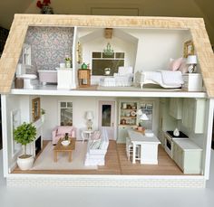 a doll house is shown with furniture and decor on the top floor, as well as a living room