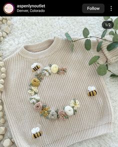 a sweater with flowers and bees on it