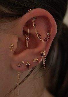 a close up of a person's ear with different types of jewelry on it