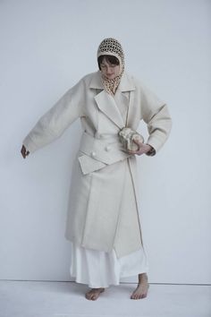 This sweeping statement coat exudes oversized elegance with its wide lapels leading to a romantic deep V neckline. Falling just above the ankles, the Snegurochka Cream Wool Hemp Shell Buttons Coat is both cozy and sophisticated. Made from a blend of durable hemp and wool fibers, its sturdy structure is punctuated with uniquely handcrafted ceramic shell buttons. Lined.Composition 40% Hemp 60% Wool and it´s undyed.Lining 100% viscoseTrimming 100% ceramic glazed handmade shell buttonsSizesOversize. Elegant Oversized Outerwear With Lapel Collar, Spring Double-breasted Wool Coat, Single Breasted Shawl Collar Outerwear For Spring, Spring Single Breasted Shawl Collar Outerwear, Oversized Beige Shawl Collar Outerwear, Chic Beige Pea Coat With Lapel Collar, Elegant Long Pea Coat For Spring, Elegant Long Spring Pea Coat, Elegant Spring Long Pea Coat