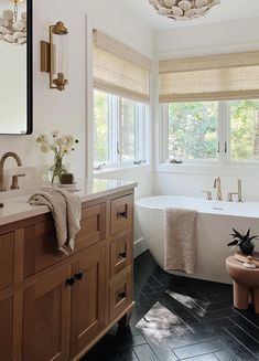 a bath room with a tub a sink and a large mirror on the wall above it